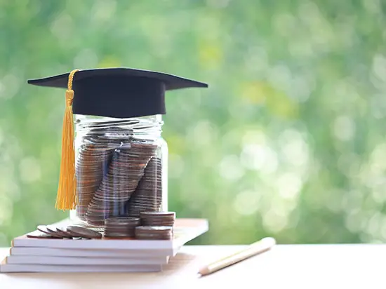Image of a jar of coins with a graduation cap on top
