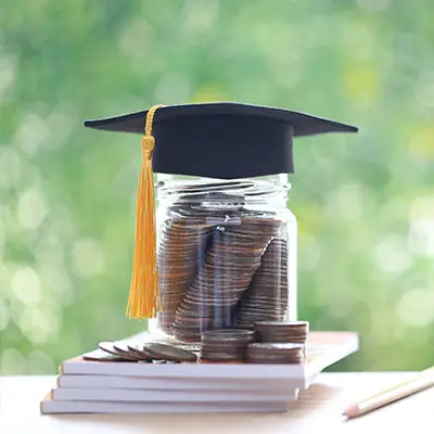 Image of jar full of coins with a graduation cap