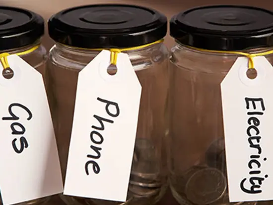 Image of jars full of coins labeled with expenses