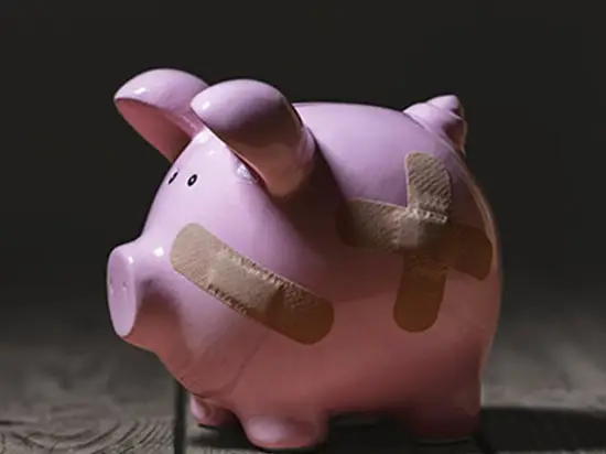 Image of damaged piggy bank with bandaids