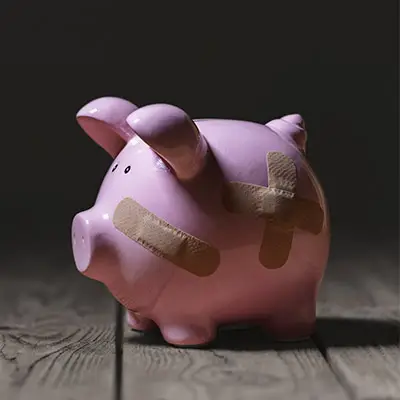 Image of broken piggy bank with bandaids