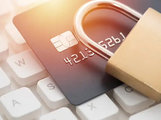 Image of a credit card laying on a keyboard with a lock