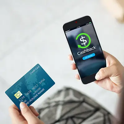Image of person holding credit card looking at an app