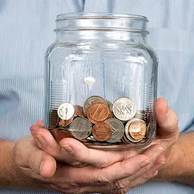 Image of man holding jar of money
