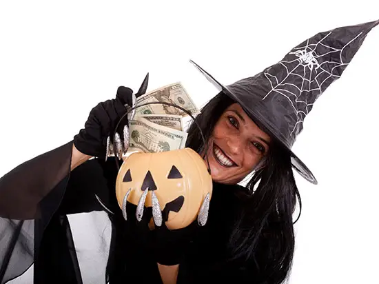 Image of woman dressed as a witch holding money