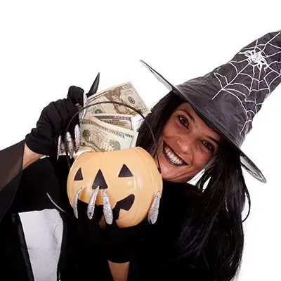 Image of woman dressed as a witch holding cash