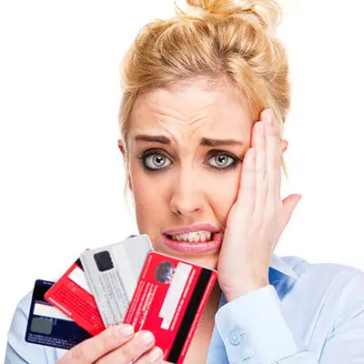 Image of woman holding many credit cards looking bewildered