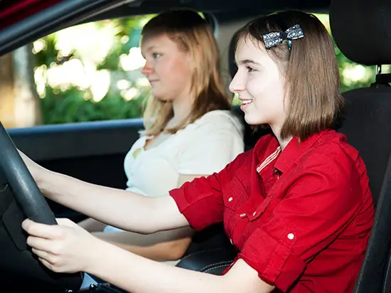 Image of teen girl driving with her mom