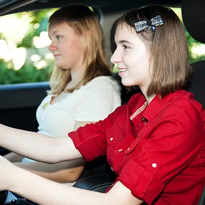 Image of teen driving a car with mother