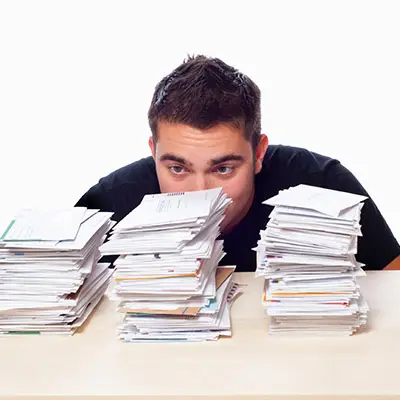 Image of man in front of a stack of bills