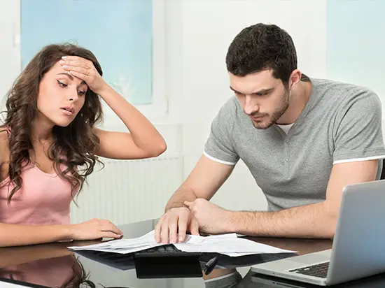 Image of stressed couple looking at bills