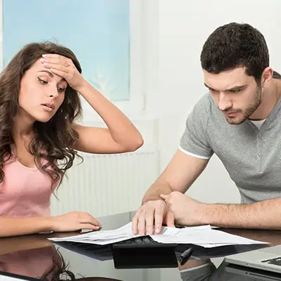 Image of stressed couple looking at bills.