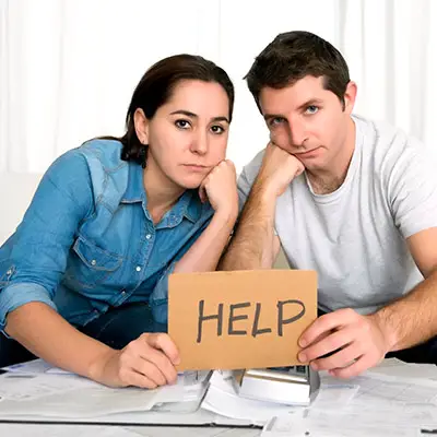 Image of couple holding help sign
